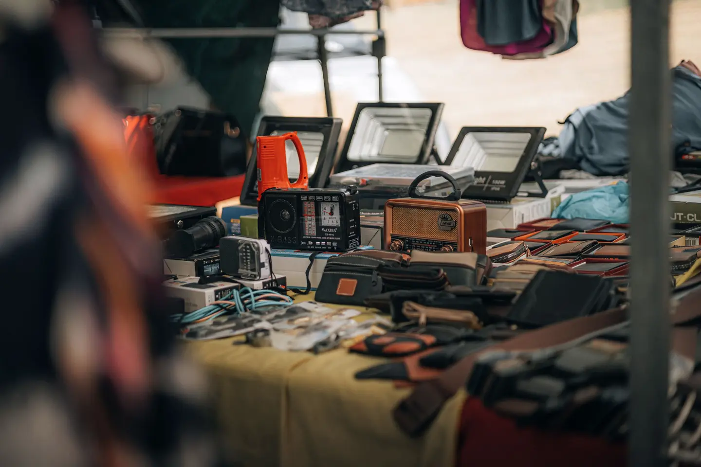 A market table covered in radios, cameras and small electronics
